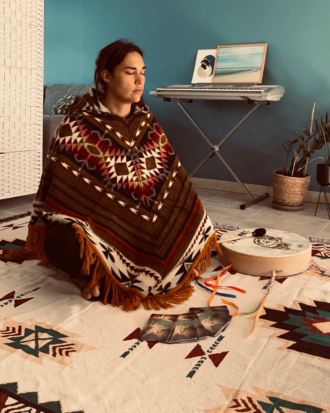 Jade avec son tambour, dans une maison, sur un tapis aux motifs amérindiens