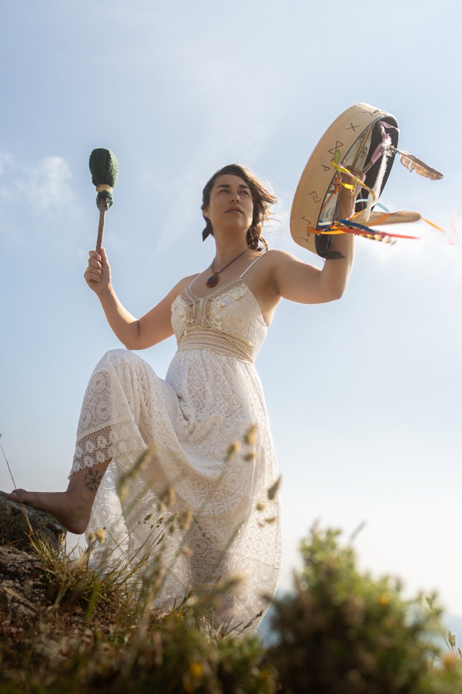 Jade en robe blanche, tambour levé vers le ciel