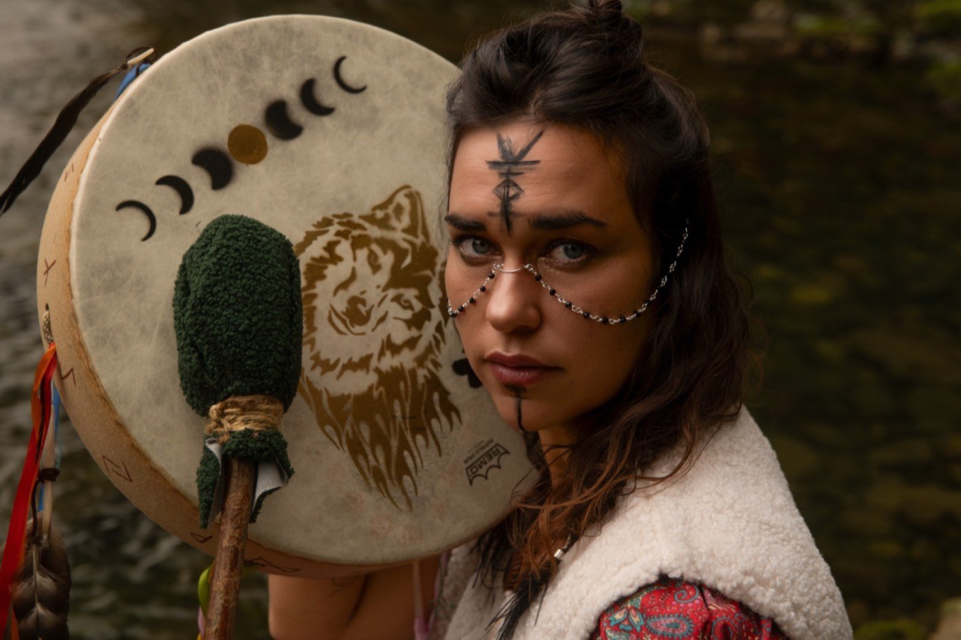 Jade, le visage peint, tenant son tambour orné d'un loup